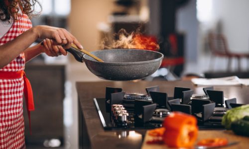 woman-chef-cooking-vegetables-pan_1303-22289